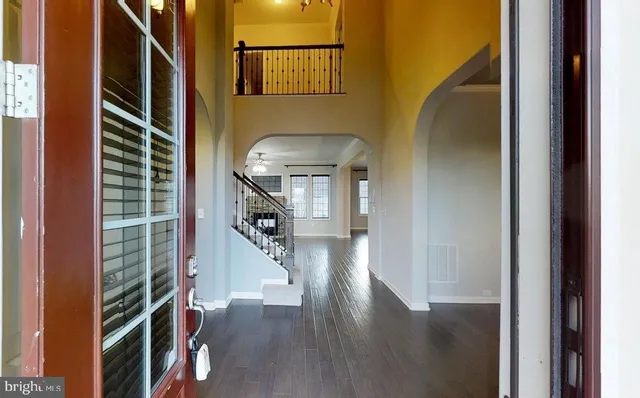 a living room with furniture large window and wooden floor
