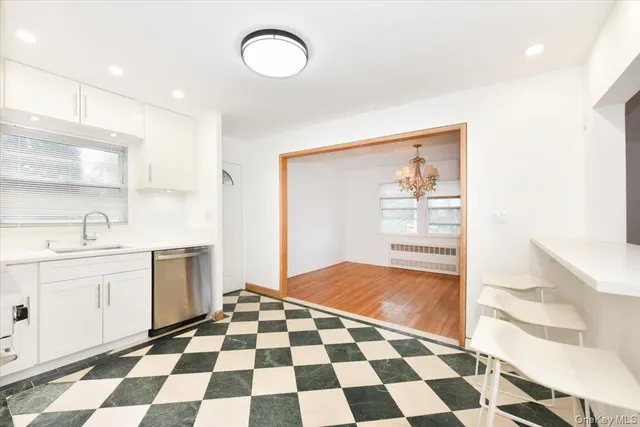 a kitchen with a checkered floor and white cabinets
