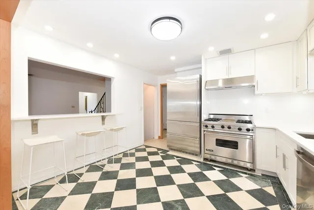 a kitchen with granite countertop stainless steel appliances a sink and a refrigerator