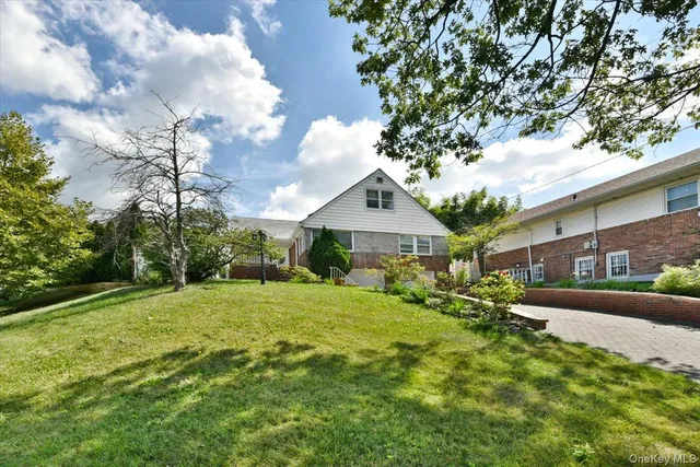 a view of a house with a big yard plants and large trees