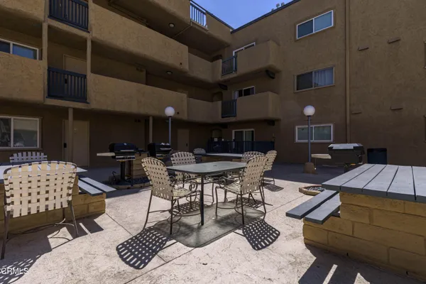 a view of a backyard with potted plants and large trees