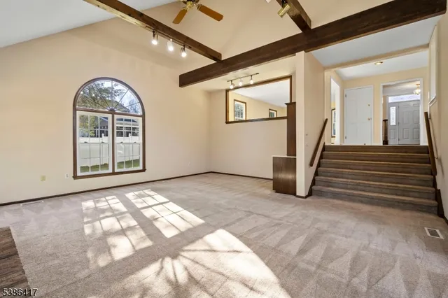 a view of a livingroom with wooden floor and stairs