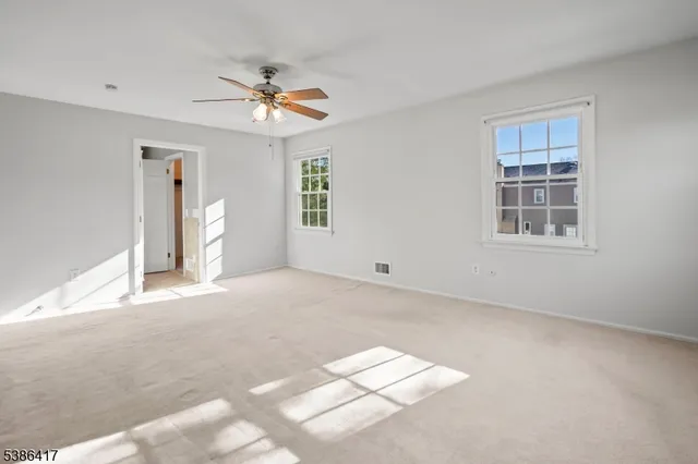 a view of a livingroom with a ceiling fan and window