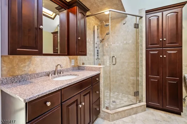 a bathroom with a granite countertop sink shower and a mirror