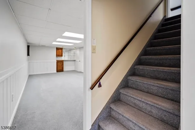 a view of staircase with white walls and a rug