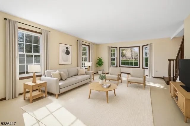 a living room with furniture and a flat screen tv with wooden floor