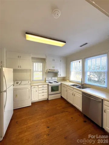 a kitchen with granite countertop white cabinets and white appliances