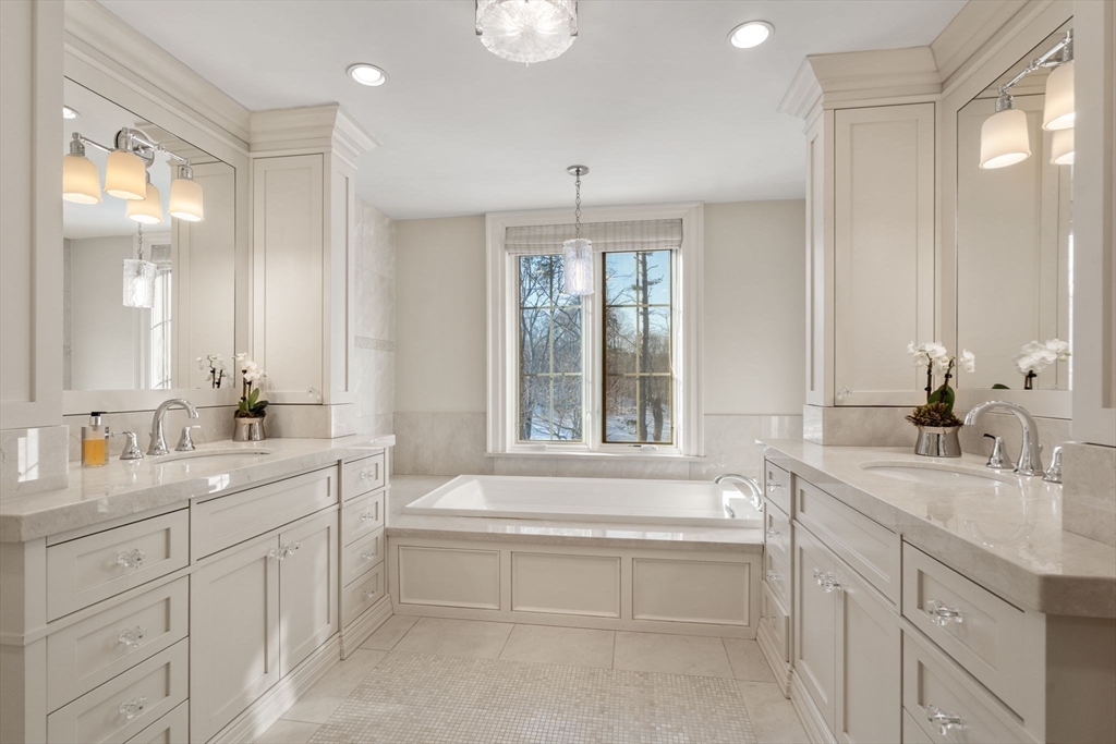 11 Hillcrest Road Weston, MA 02493 - Photo 18 of 42 a bathroom with a two sinks a large mirror and a bathtub next to a window
