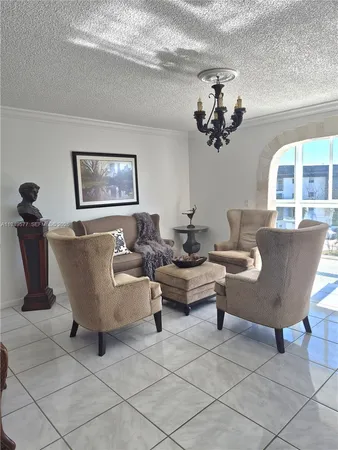a living room with couches a painting on the wall and a potted plant