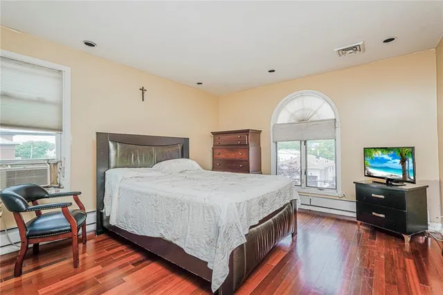 a bedroom with a bed and wooden floor