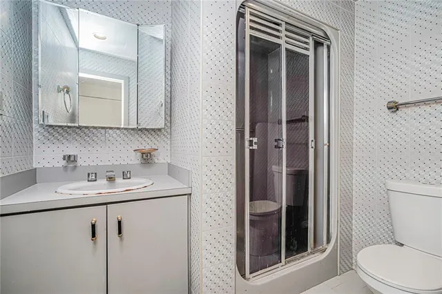 a bathroom with a toilet sink vanity and mirror