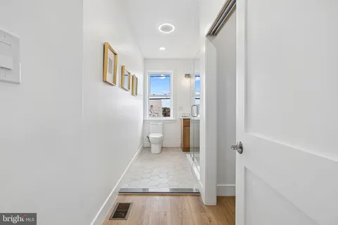 a view of a hallway with a livingroom and a bathroom with a sink