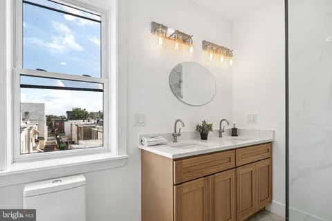 a bathroom with a sink and a mirror with window
