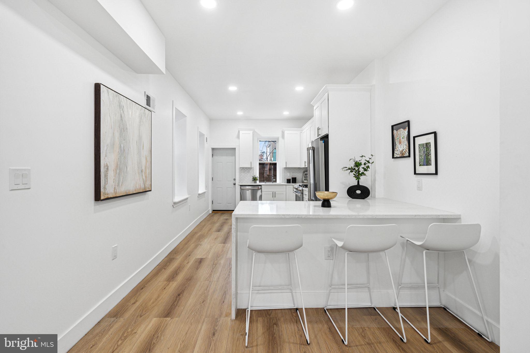 908 Reed Street Philadelphia, PA 19147 - Photo 7 of 31 a large white kitchen with wooden floor