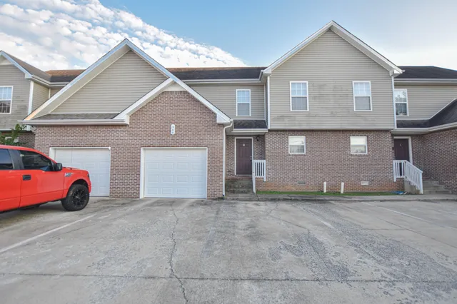 a house view with a garden and garage