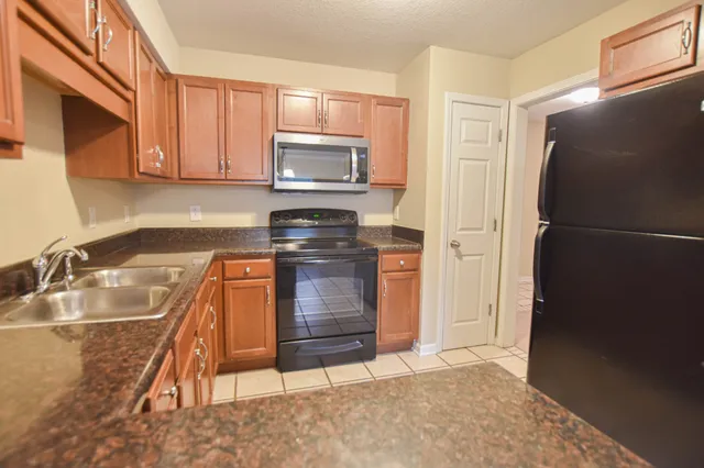 a kitchen with a refrigerator sink and cabinets