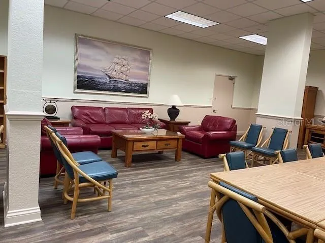 a living room with furniture a wooden floor and next to a window