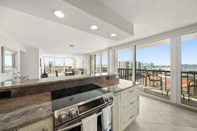 a large kitchen with kitchen island a large window in it