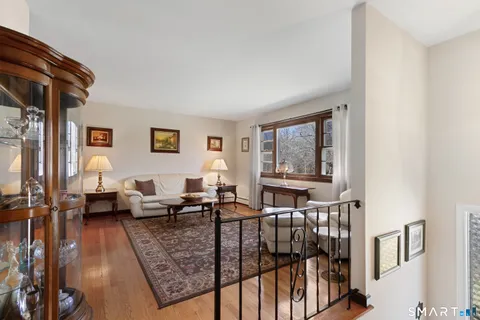 a living room with furniture large window and wooden floor