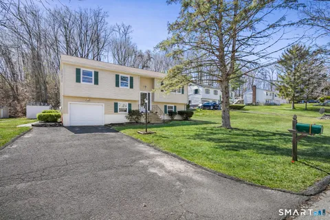 a front view of a house with a yard and trees