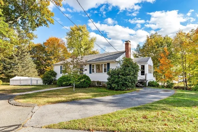 a view of a house with a big yard and large trees