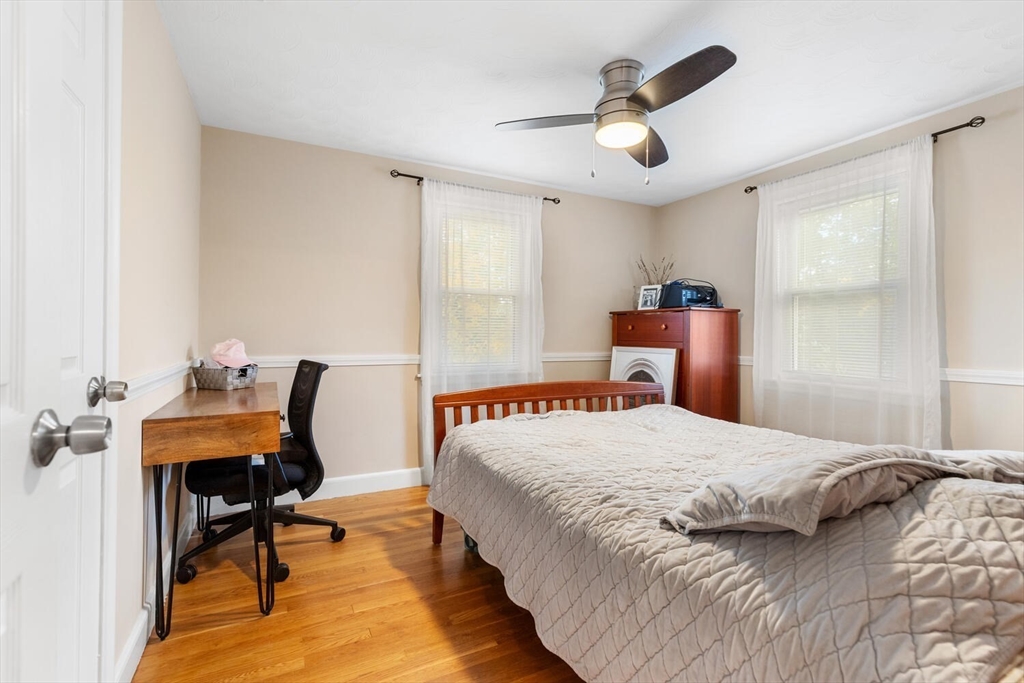 22 Wayland Road Wakefield, MA 01880 - Photo 19 of 28 a bedroom with a bed a desk and chair with wooden floor