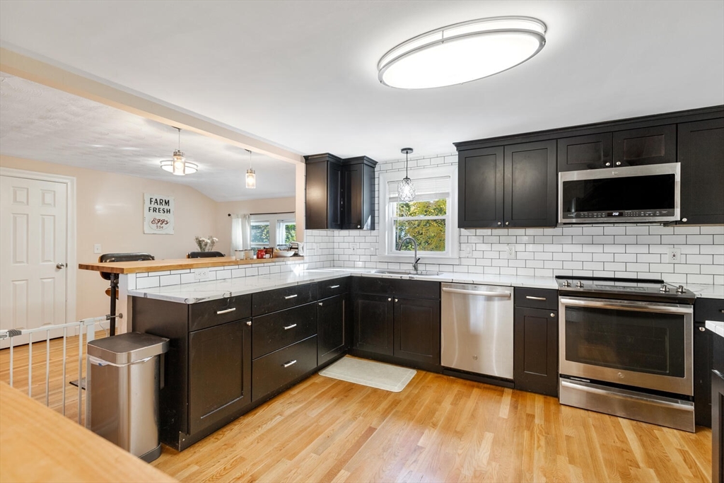 22 Wayland Road Wakefield, MA 01880 - Photo 10 of 28 a kitchen with a sink and a stove top oven with wooden floor