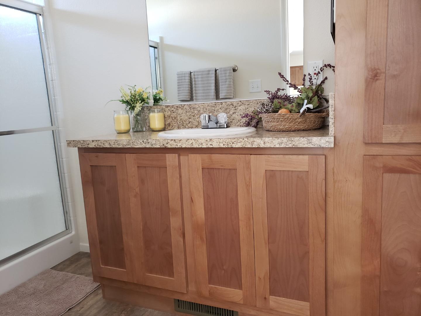 55 San Juan Grade Road, Unit 49 Salinas, CA 93906 - Photo 11 of 14 a bathroom with a granite countertop sink and a mirror