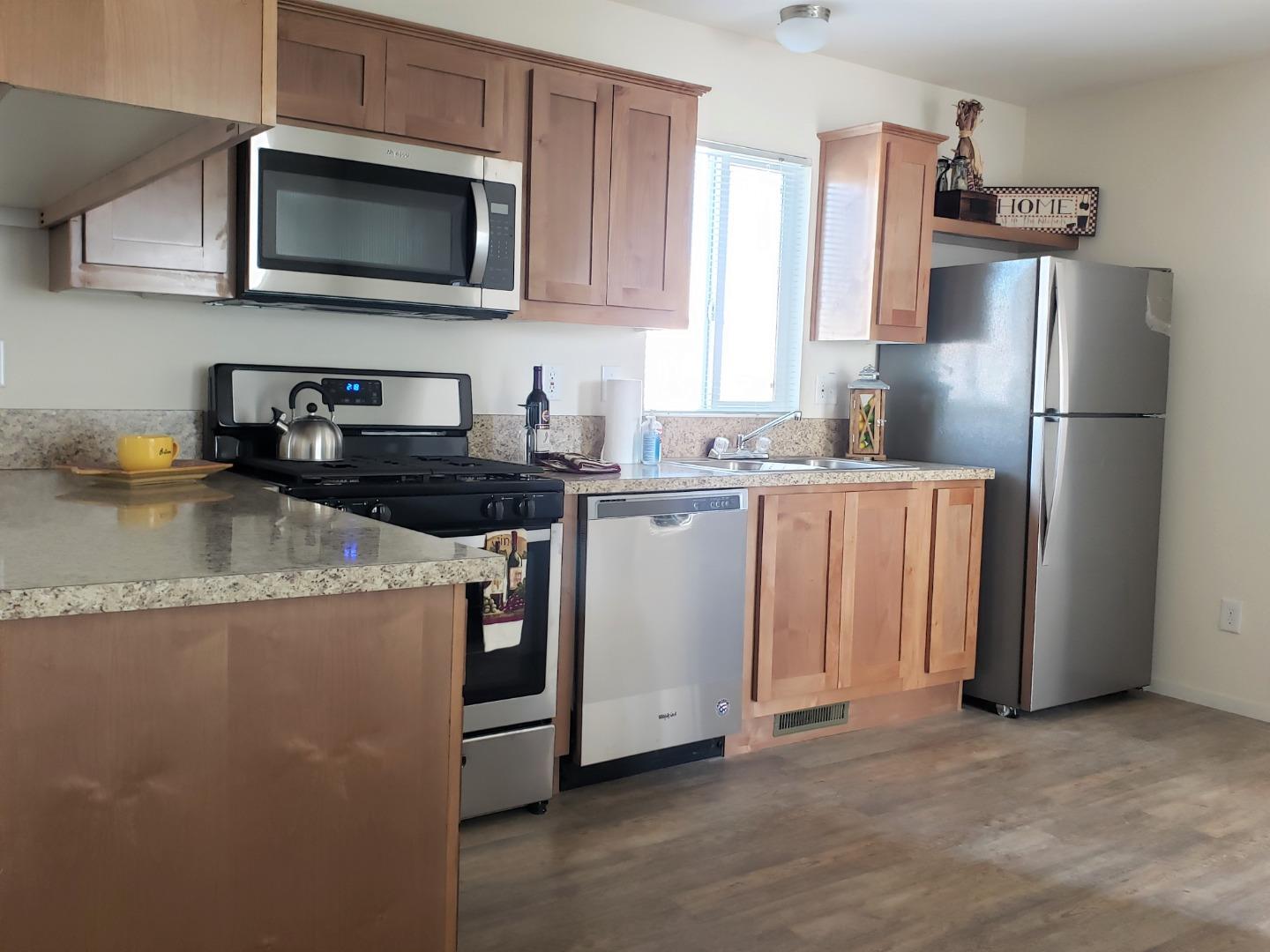 55 San Juan Grade Road, Unit 49 Salinas, CA 93906 - Photo 3 of 14 a kitchen with stainless steel appliances granite countertop a refrigerator a stove a sink a microwave and cabinets