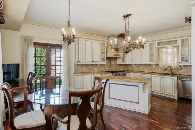 a kitchen with kitchen island granite countertop a center island a stove cabinets a dining table and chairs