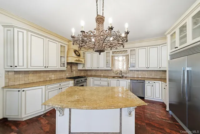 a kitchen with kitchen island granite countertop a sink cabinets and stainless steel appliances