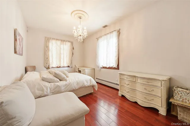 a spacious bedroom with a bed and wooden floor