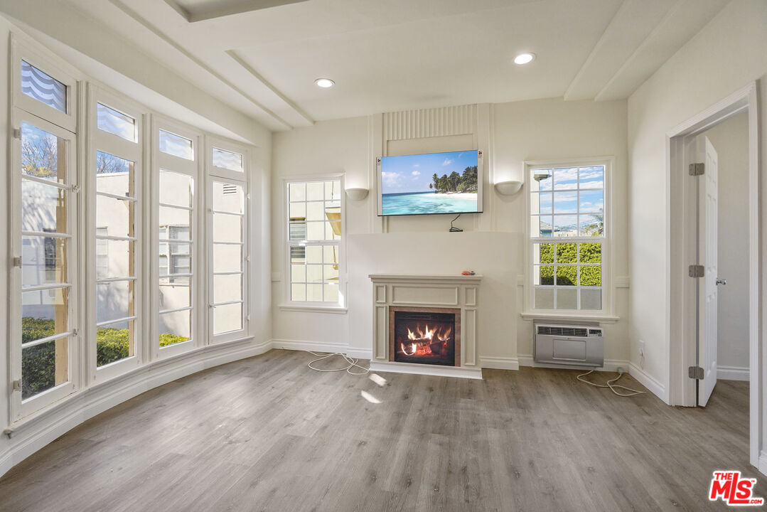 a view of an empty room with a fireplace and a window