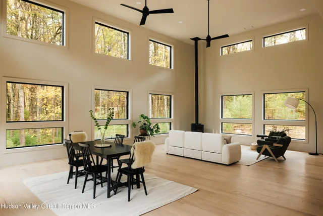 a living room with furniture floor to ceiling window and a table