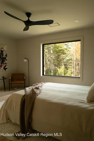 a bedroom with a bed and a large window