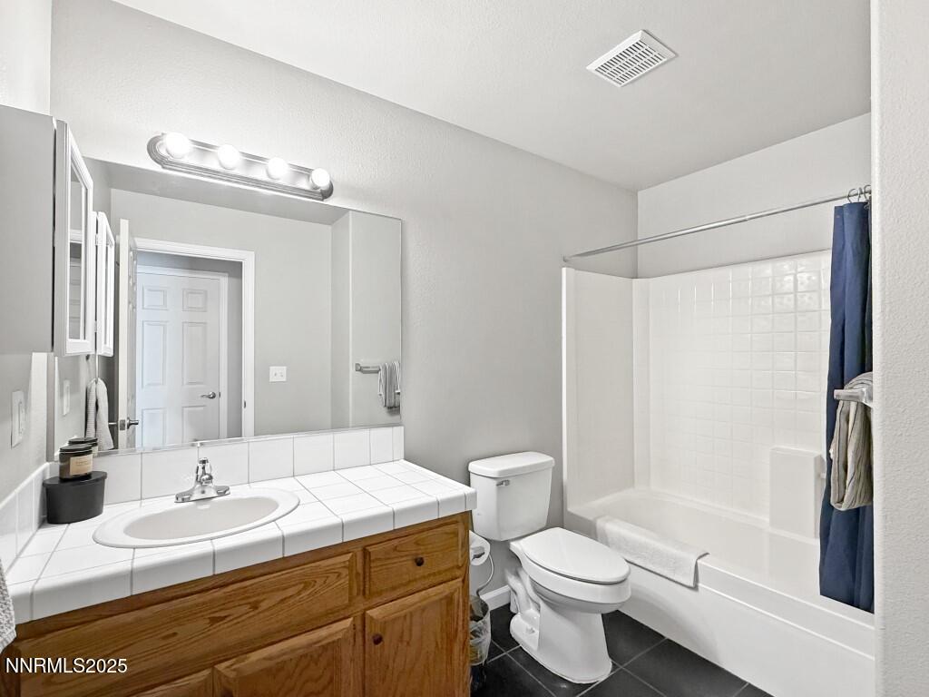 2119 Fort Bridger Road Fernley, NV 89408 - Photo 14 of 18 a bathroom with a sink a toilet a mirror and shower