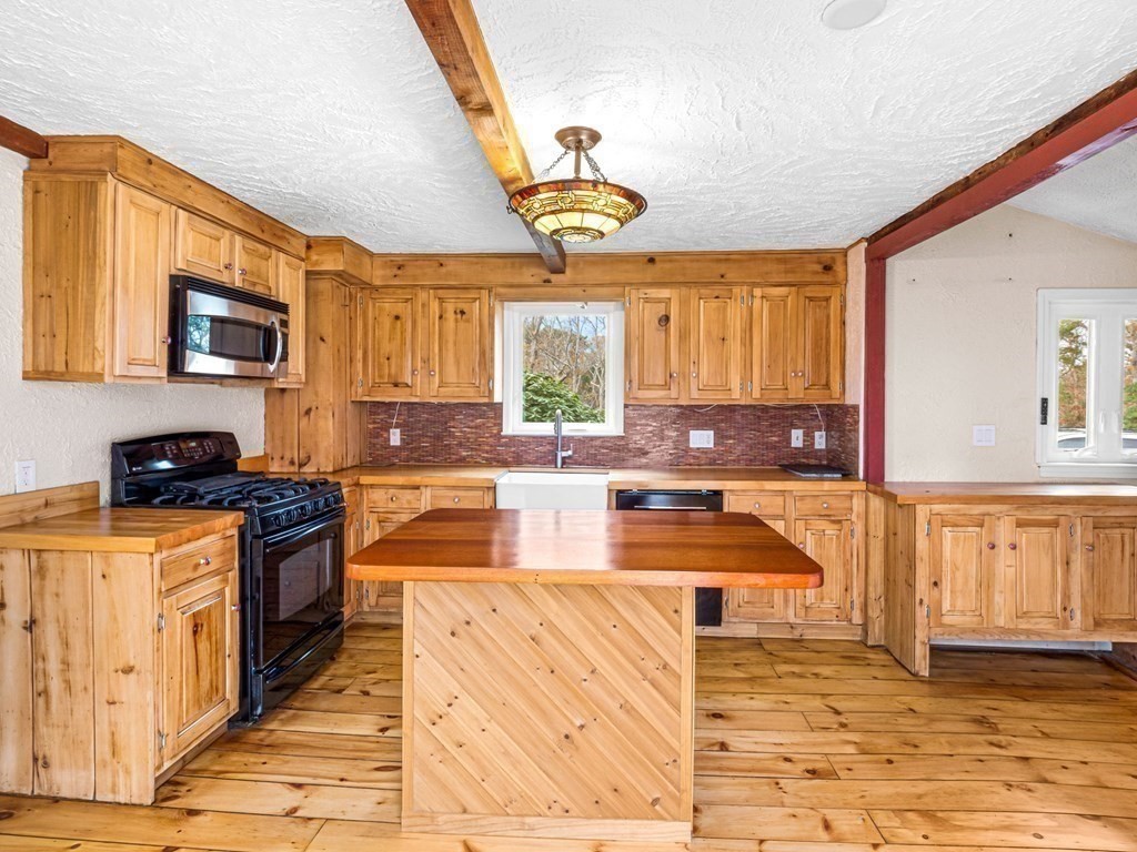 775 Shore Road Bourne, MA 02559 - Photo 13 of 42 a kitchen with stainless steel appliances granite countertop a stove a sink and a microwave