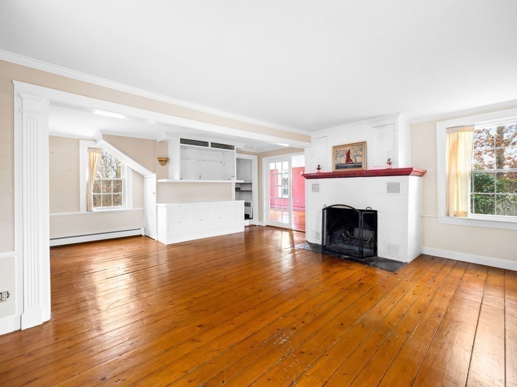 775 Shore Road Bourne, MA 02559 - Photo 23 of 42 a view of empty room with wooden floor and fireplace