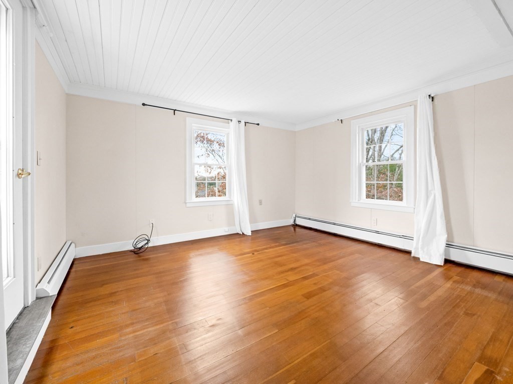 775 Shore Road Bourne, MA 02559 - Photo 34 of 42 an empty room with wooden floor and windows