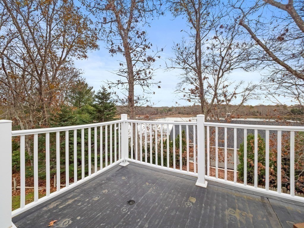 775 Shore Road Bourne, MA 02559 - Photo 37 of 42 a balcony with wooden floor and fence