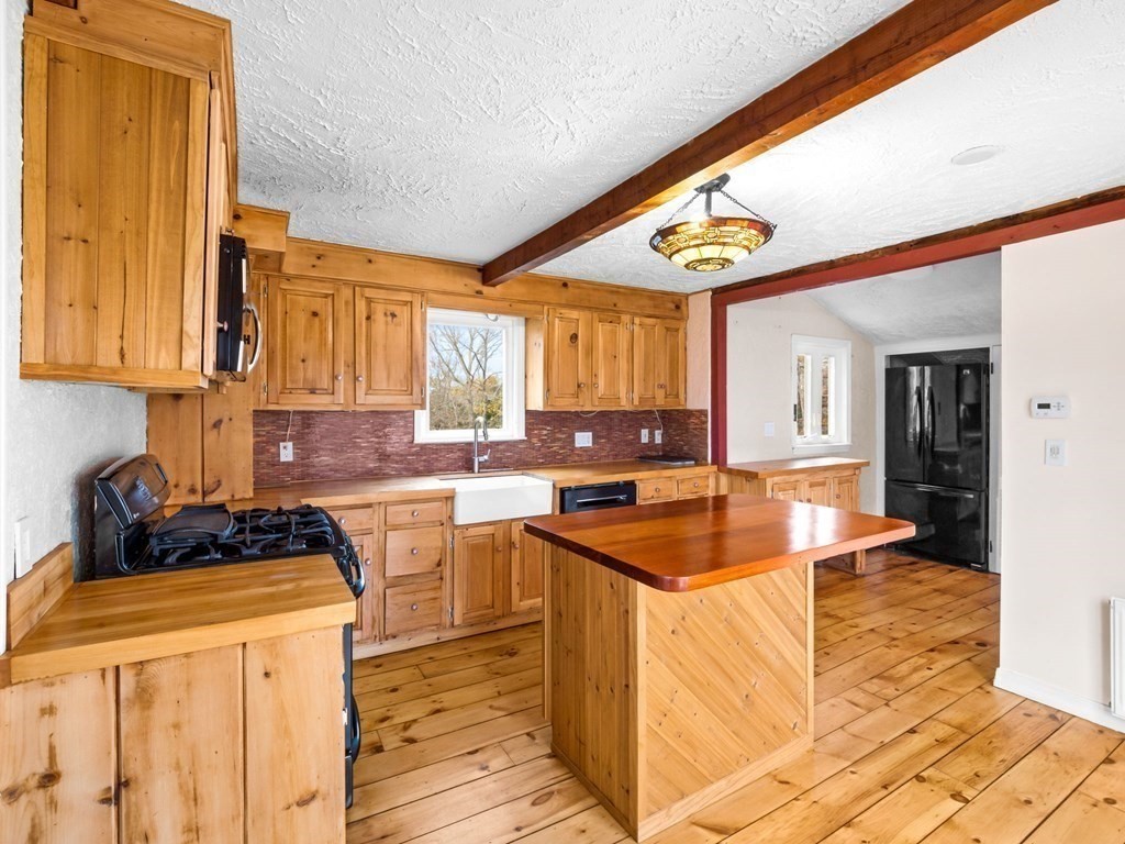 775 Shore Road Bourne, MA 02559 - Photo 9 of 42 a kitchen with stainless steel appliances granite countertop a sink and a stove