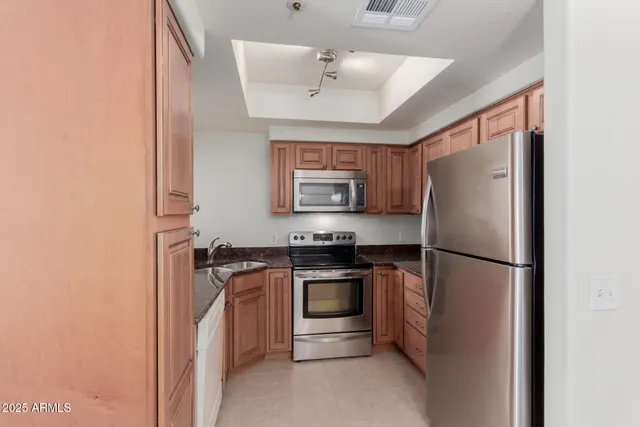 a kitchen with stainless steel appliances granite countertop a refrigerator sink and stove