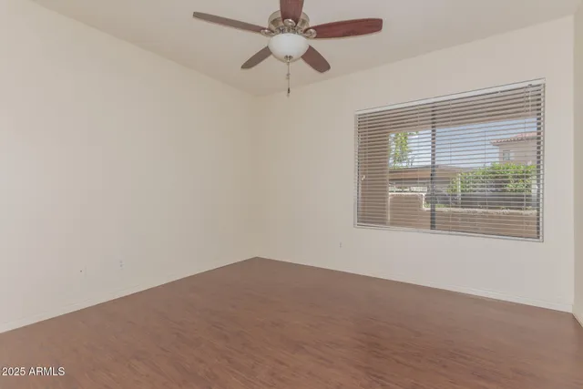 an empty room with a window and a fan