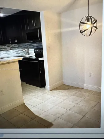 a kitchen with granite countertop a stove a sink and a microwave