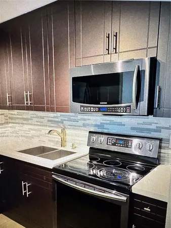 a kitchen with granite countertop a stove and a sink
