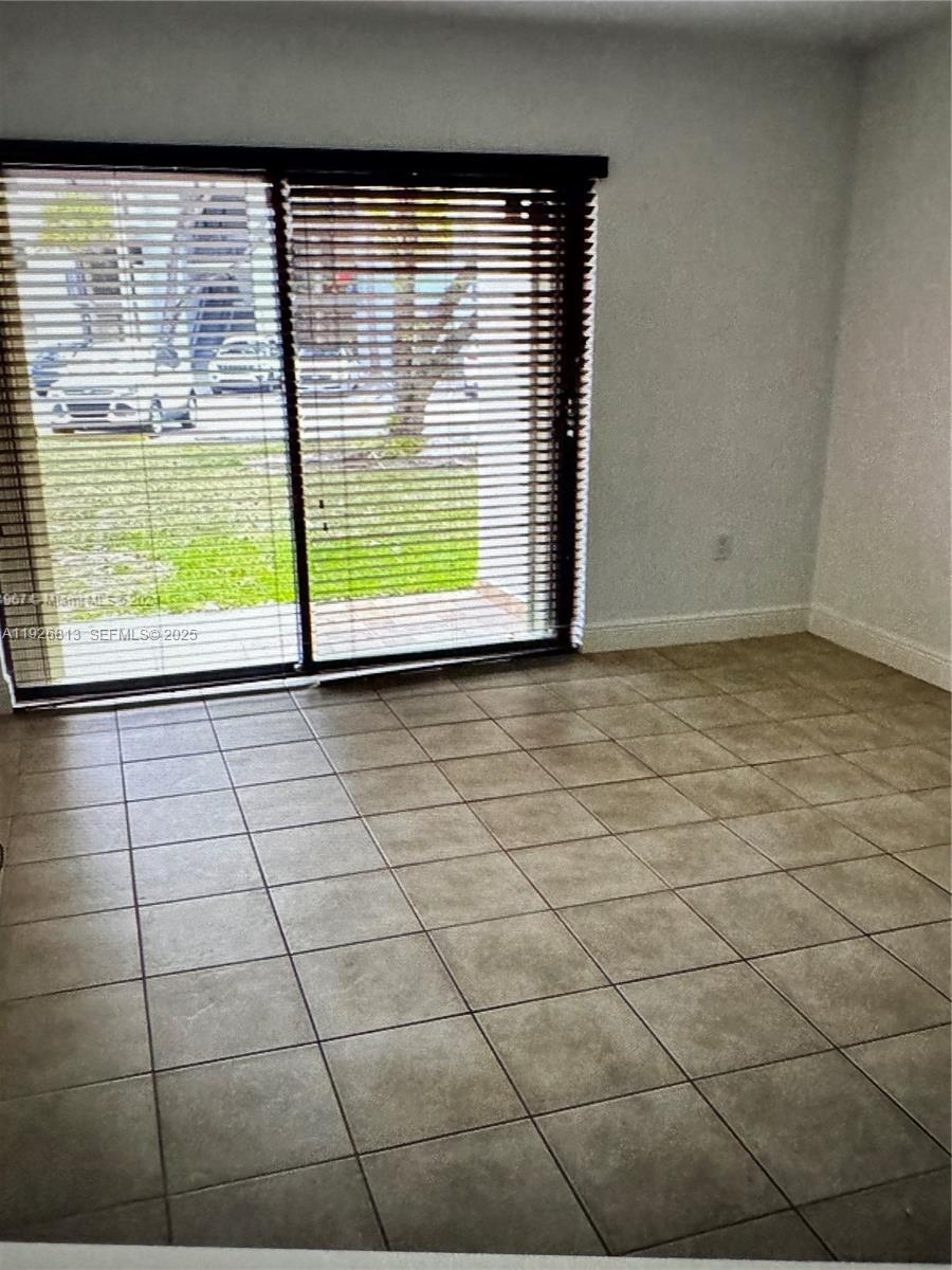 7130 Northwest 179th Street, Unit 108 Hialeah, FL 33015 - Photo 8 of 11 a view of an empty room with a window