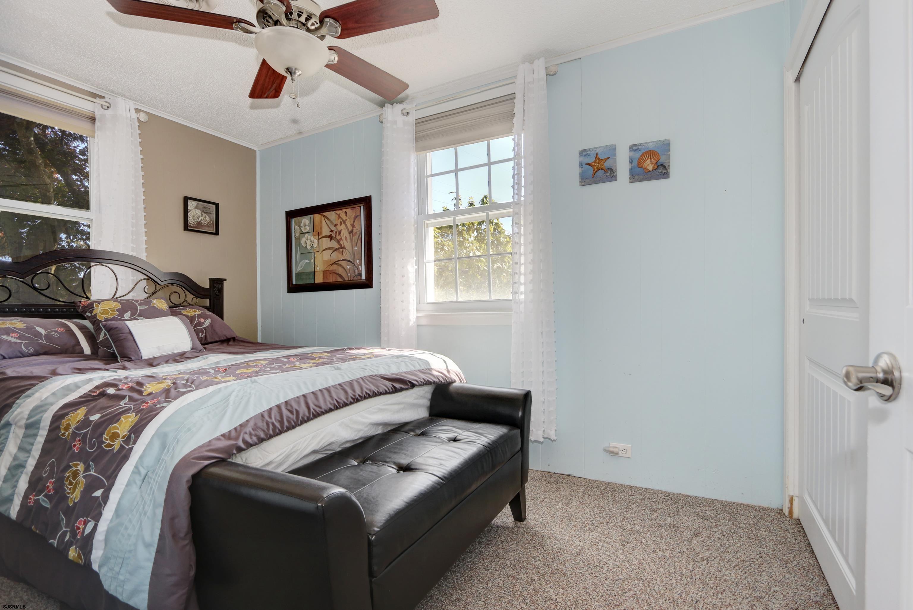 34 North Shore Road Marmora, NJ 08223 - Photo 14 of 37 a bedroom with a bed and a chandelier