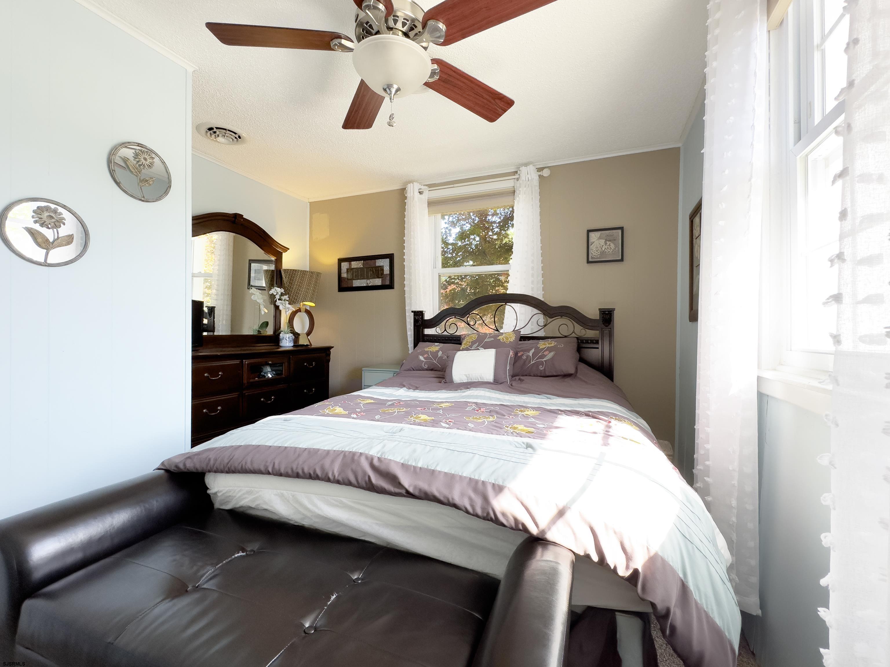 34 North Shore Road Marmora, NJ 08223 - Photo 16 of 37 a bedroom with a bed and a chandelier