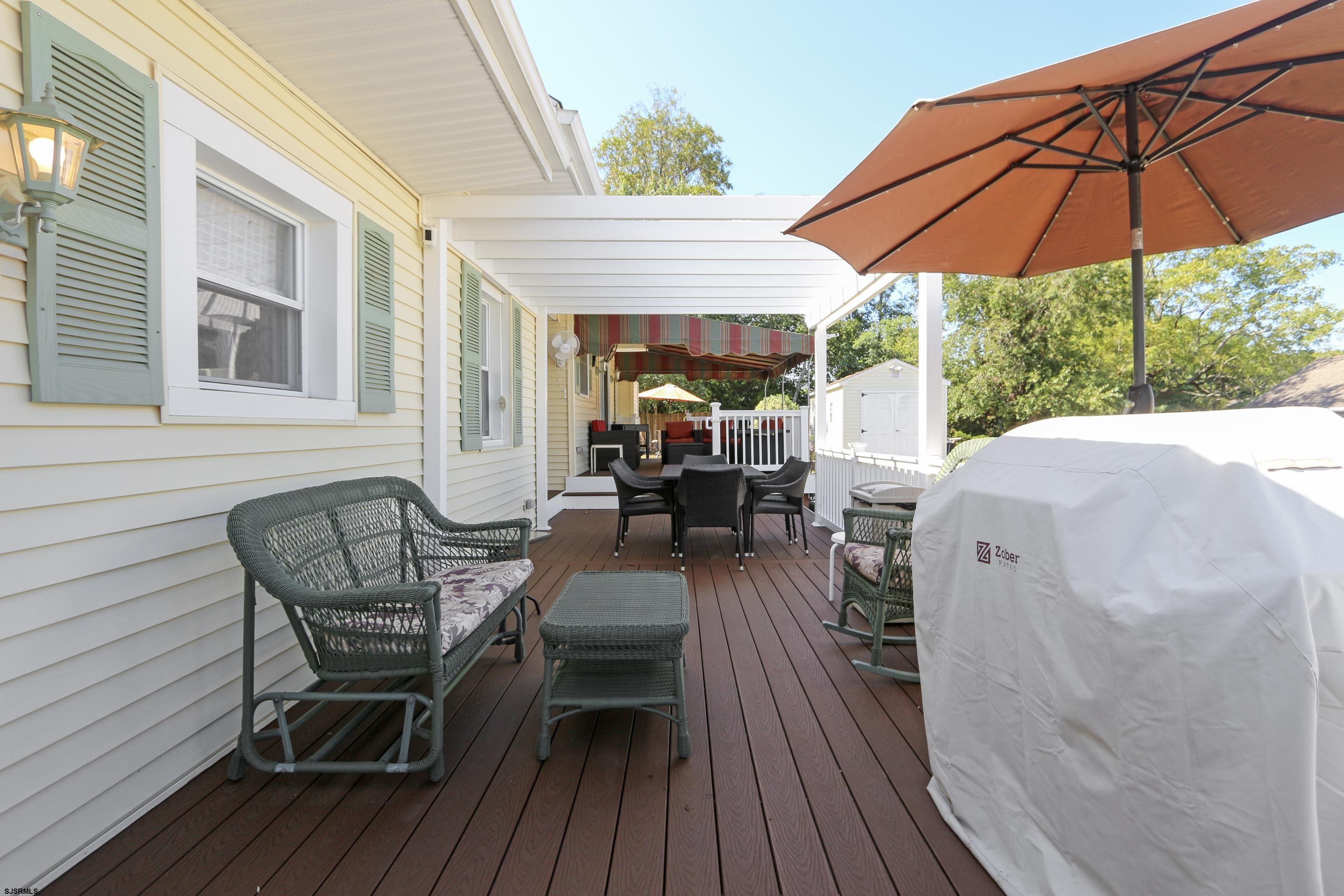 34 North Shore Road Marmora, NJ 08223 - Photo 25 of 37 a view of a patio with table and chairs under an umbrella with wooden floor