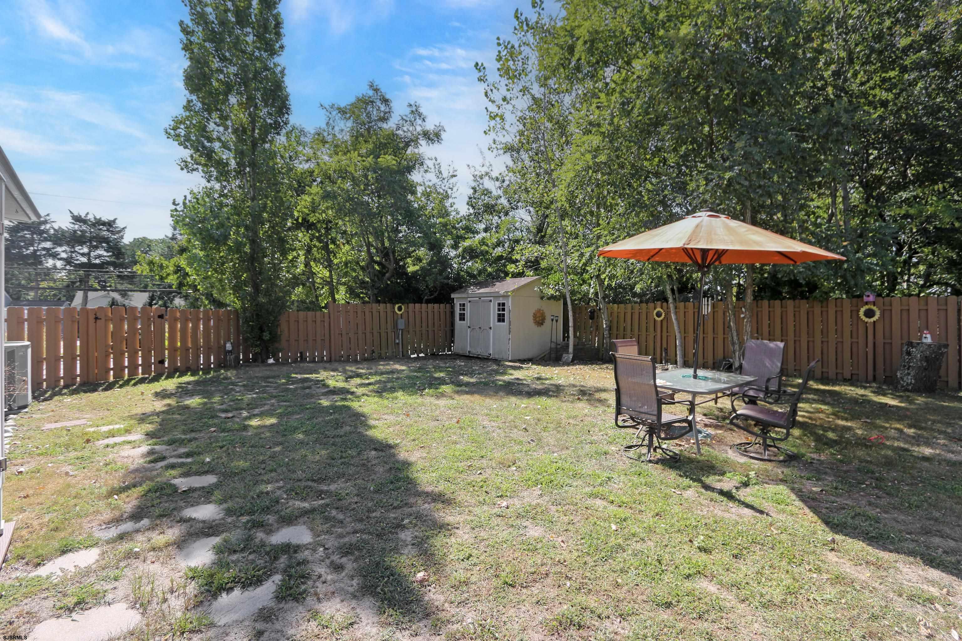 34 North Shore Road Marmora, NJ 08223 - Photo 31 of 37 a backyard of a house with table and chairs